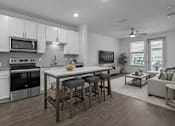 Thumbnail 21 of 41 - A modern kitchen with white cabinets and a large island.
