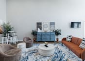 Thumbnail 11 of 29 - A living room with a brown sofa, a round coffee table, and a blue cabinet.