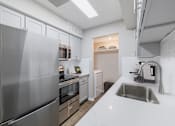 Thumbnail 8 of 62 - A modern kitchen with a stainless steel refrigerator and a sink.
