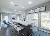 Thumbnail 30 of 62 - A modern kitchen with a long white island and bar stools.