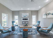Thumbnail 25 of 62 - A living room with blue chairs and a fireplace.