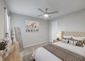 Thumbnail 9 of 62 - A bedroom with a large bed and a ceiling fan.