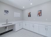 Thumbnail 45 of 62 - A bathroom with a sink and two pictures on the wall.