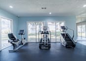 Thumbnail 38 of 62 - A spacious gym with a treadmill, elliptical trainer, and a stationary bike.