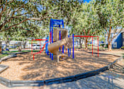 Thumbnail 62 of 62 - A playground with a blue slide and red bars.