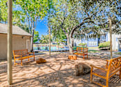 Thumbnail 54 of 62 - A park with wooden benches and trees.