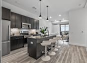 Thumbnail 25 of 35 - A modern kitchen with dark wood cabinets and a central island.