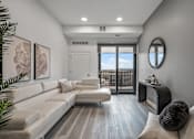 Thumbnail 30 of 35 - A modern living room with a white couch and a round mirror on the wall.