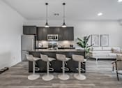 Thumbnail 26 of 35 - A modern kitchen with a bar stool set.