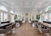 Thumbnail 9 of 33 - a dining room with tables and chairs and a large room with windows