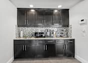 Thumbnail 36 of 38 - A kitchen with black cabinets and a black and white checkered backsplash.
