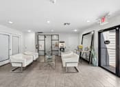 Thumbnail 34 of 38 - A spacious room with white chairs and a glass table.
