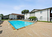 Thumbnail 14 of 23 - A swimming pool surrounded by chairs and a fence in front of a building.