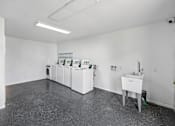 Thumbnail 17 of 23 - A white room with a table and a wall-mounted cabinet.