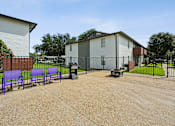 Thumbnail 15 of 23 - A park with purple benches and a black fence.
