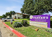 Thumbnail 22 of 23 - A sign for The Parker II Apartments is displayed in front of a building.