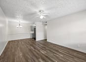 Thumbnail 3 of 23 - A room with a ceiling fan and wooden flooring.