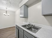 Thumbnail 2 of 23 - A kitchen with a sink and a cabinet.