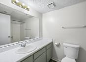 Thumbnail 8 of 23 - A white toilet sits next to a sink in a small bathroom.