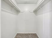 Thumbnail 10 of 23 - A white closet with a carpeted floor and white walls.
