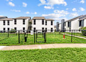 Thumbnail 17 of 22 - A row of white houses with black fences and a red fire hydrant.