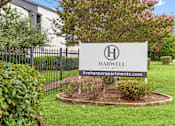 Thumbnail 19 of 22 - A sign for Harwell Apartments is displayed in front of a building.