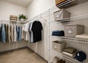 Thumbnail 5 of 44 - A room with a white wall and a shelf with clothes and boxes.