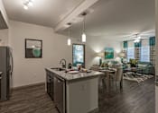 Thumbnail 5 of 40 - A modern kitchen with dark wood floors and stainless steel appliances.