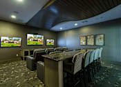 Thumbnail 24 of 40 - A conference room with a long table and chairs, a television on the wall, and a carpeted floor.
