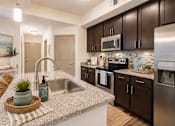 Thumbnail 2 of 44 - A kitchen with a sink, stove, and refrigerator.