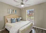 Thumbnail 4 of 16 - A bedroom with a large bed and a ceiling fan.