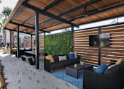 Thumbnail 42 of 47 - A patio with a black couch and a TV mounted on a wooden wall.