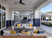 Thumbnail 28 of 47 - A modern outdoor living space with a wooden sofa and yellow pillows.