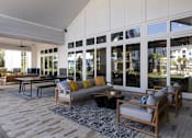 Thumbnail 34 of 47 - A modern outdoor living space with a wooden floor and furniture.