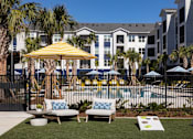 Thumbnail 35 of 47 - A yellow umbrella is in the foreground of a pool area.