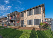 Thumbnail 18 of 19 - An exterior photo of a two-story apartment  building (Costa Mesa Apartments) with stairs and greenery space