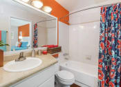 Thumbnail 7 of 19 - a bathroom with a shower and a sink and a toilet