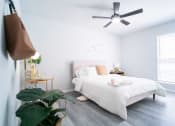 Thumbnail 7 of 20 - a white bedroom with a bed and a ceiling fan