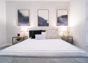 Thumbnail 9 of 20 - a bedroom with a bed and paintings on the wall