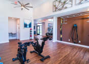 Thumbnail 16 of 20 - a home gym with exercise bikes and a ceiling fan