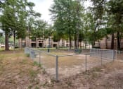 Thumbnail 31 of 32 - a fenced in area with trees and a chain link fence