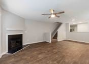 Thumbnail 13 of 36 - a living room with a fireplace and a ceiling fan