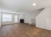 Thumbnail 14 of 36 - an empty living room with a ceiling fan and a fireplace