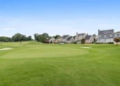 Thumbnail 17 of 36 - a view of a golf course with houses in the background