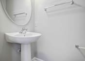 Thumbnail 35 of 36 - a white bathroom with a sink and a mirror