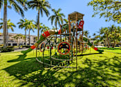 Thumbnail 40 of 40 - A playground with a green slide and a red and white striped barrier.