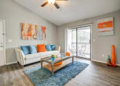 Thumbnail 2 of 19 - a living room with a couch and a coffee table and a sliding glass door
