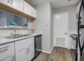 Thumbnail 4 of 19 - a kitchen with white cabinets and a sink and a refrigerator