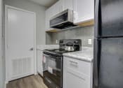 Thumbnail 3 of 19 - a kitchen with a stove and a refrigerator