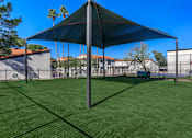 Thumbnail 25 of 26 - a large shade sail in a backyard with a playground